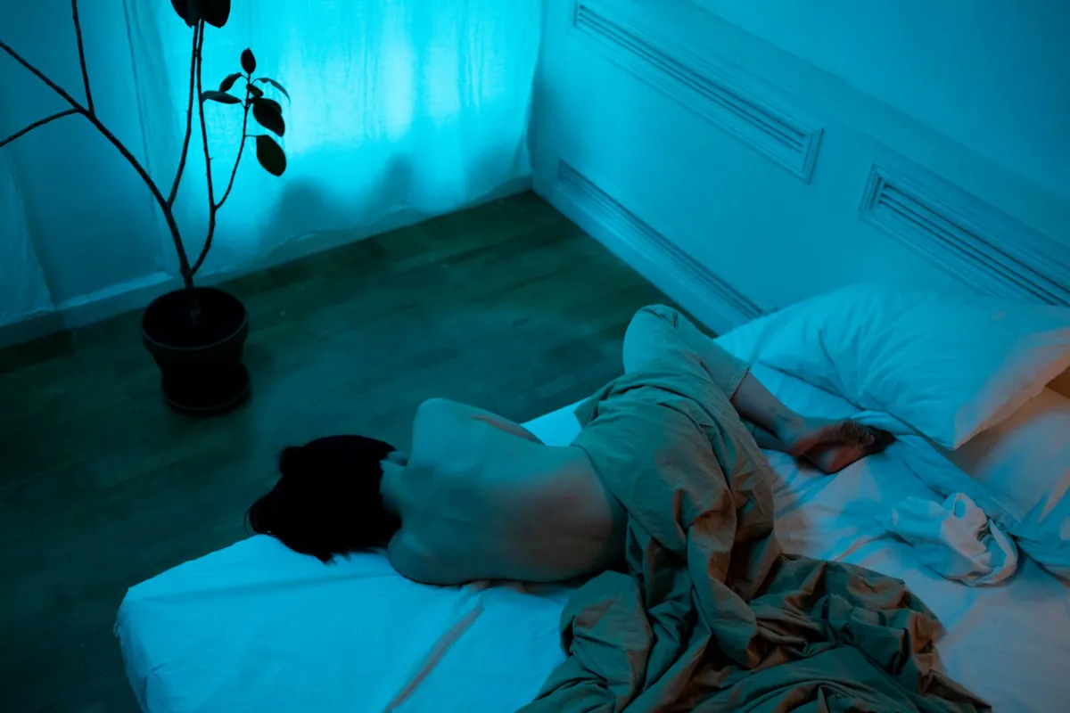 Dimly lit blue bedroom at night where someone is trying to fall asleep fast